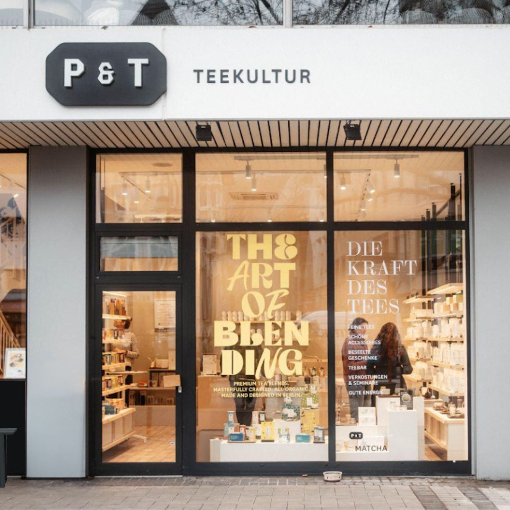 Moderner Teeladen mit schwarzem P & T Schild und gelbem Schriftzug 'THE ART OF BLENDING'.