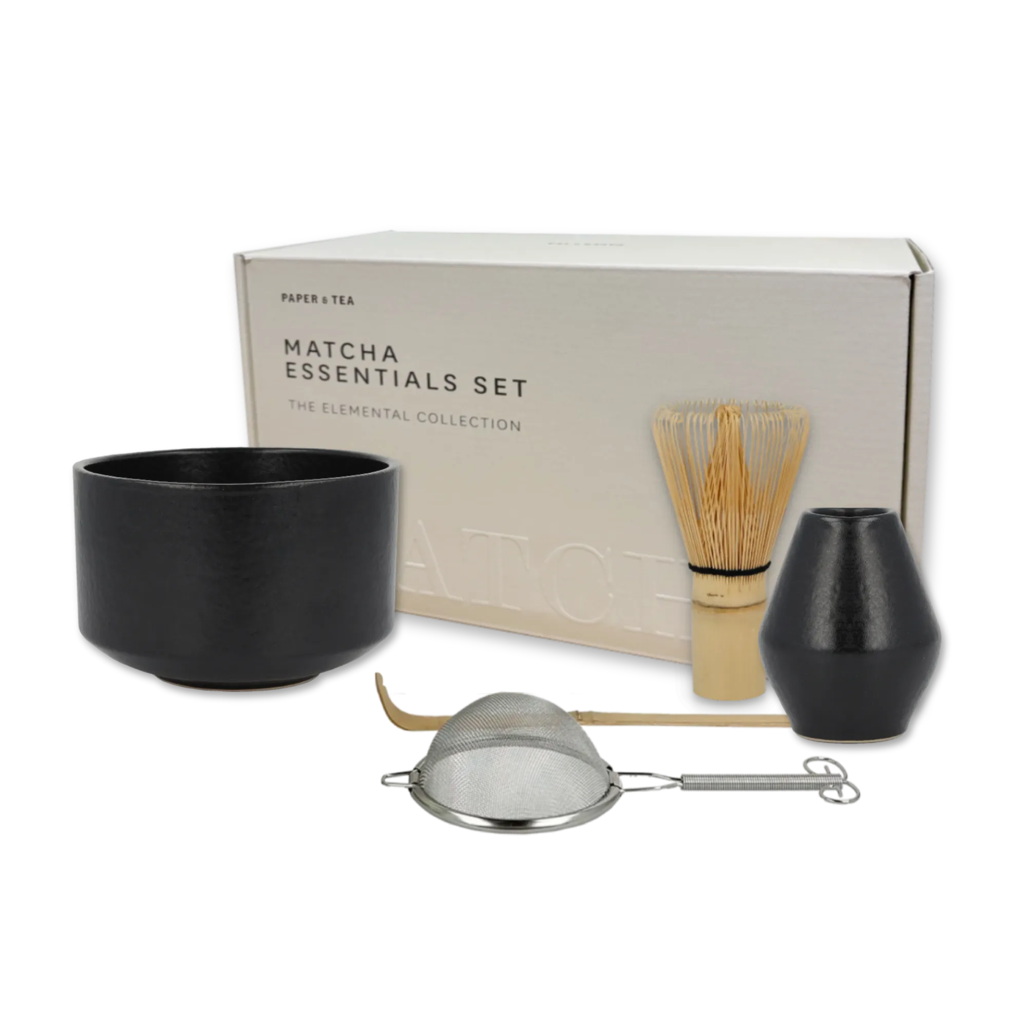 MATCHA ESSENTIALS SET von PAPER & TEA mit schwarzer Keramikschale, Bambusbesen, Löffel und Teesieb vor weißer Verpackung.