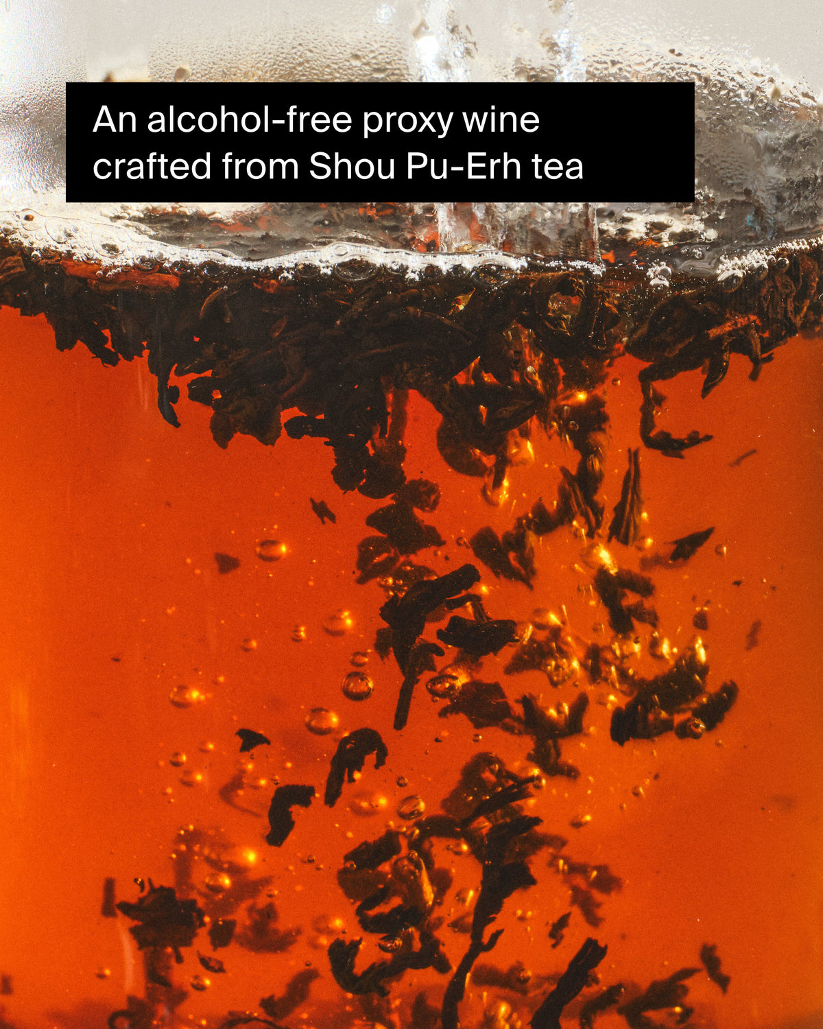 Shou Pu-Erh-Teeblätter in bernsteinfarbener Flüssigkeit, alkoholfreier Proxy-Wein mit Schaum.