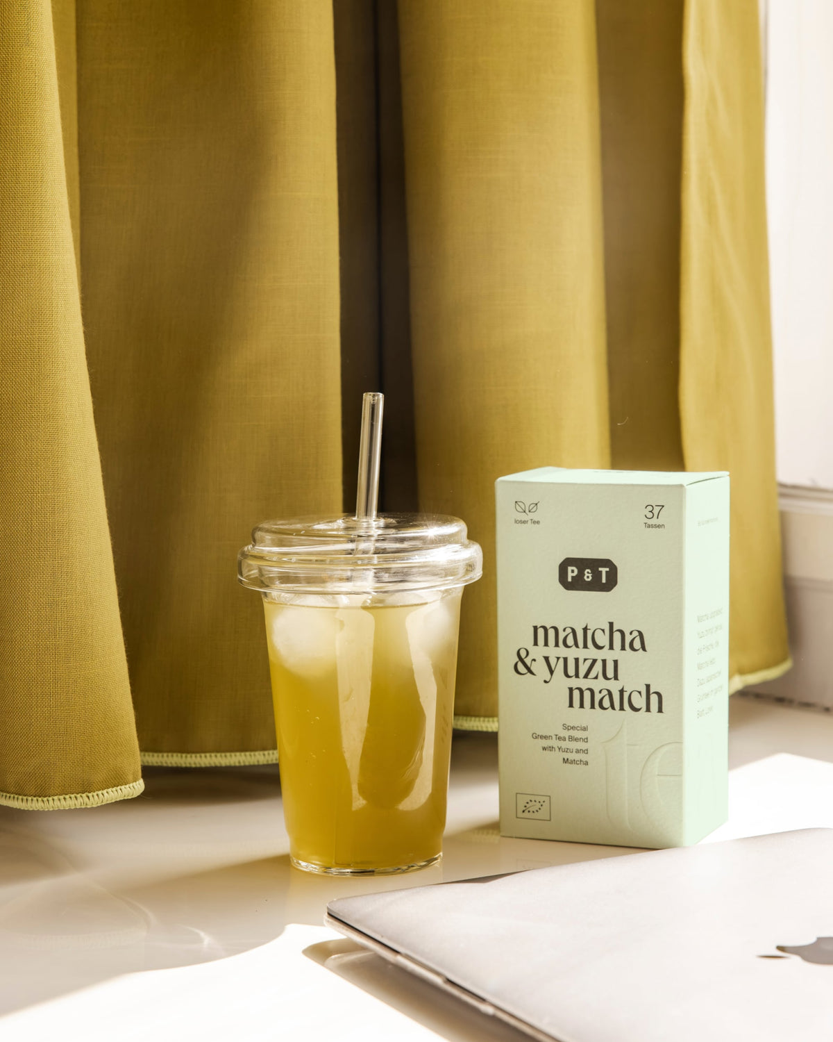 Limitierte Matcha-und-Yuzu-Grünteemischung von P&T mit Eis-Matcha-Getränk auf weißem Hintergrund.